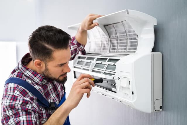 man servicing ac unit