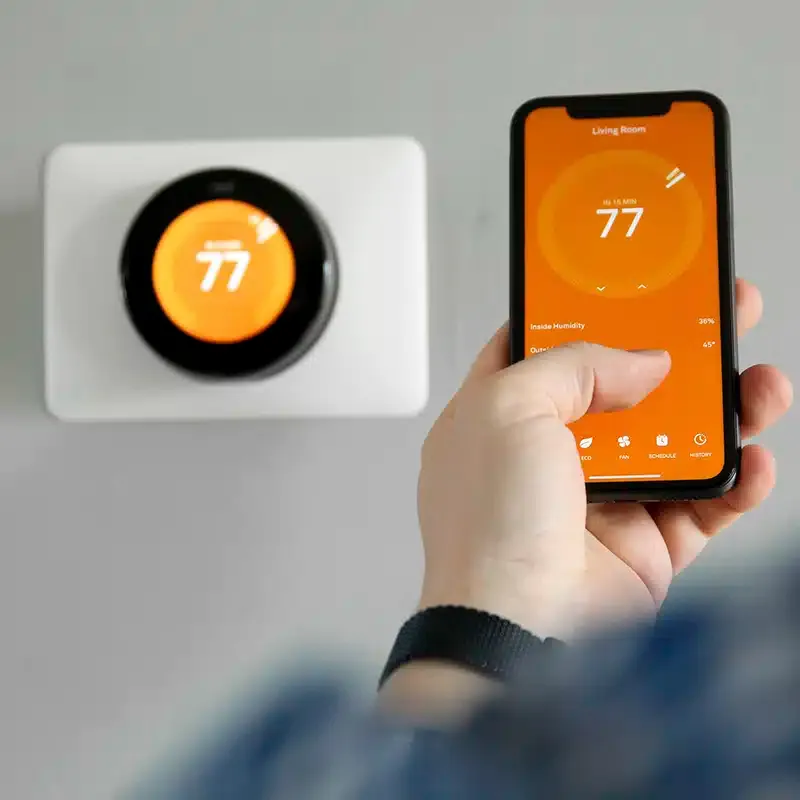 adjusting smart thermostat with phone
