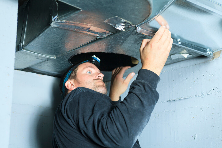 HVAC technician inspecting for mold in the ductwork of an air conditioner in Bloomington, MN