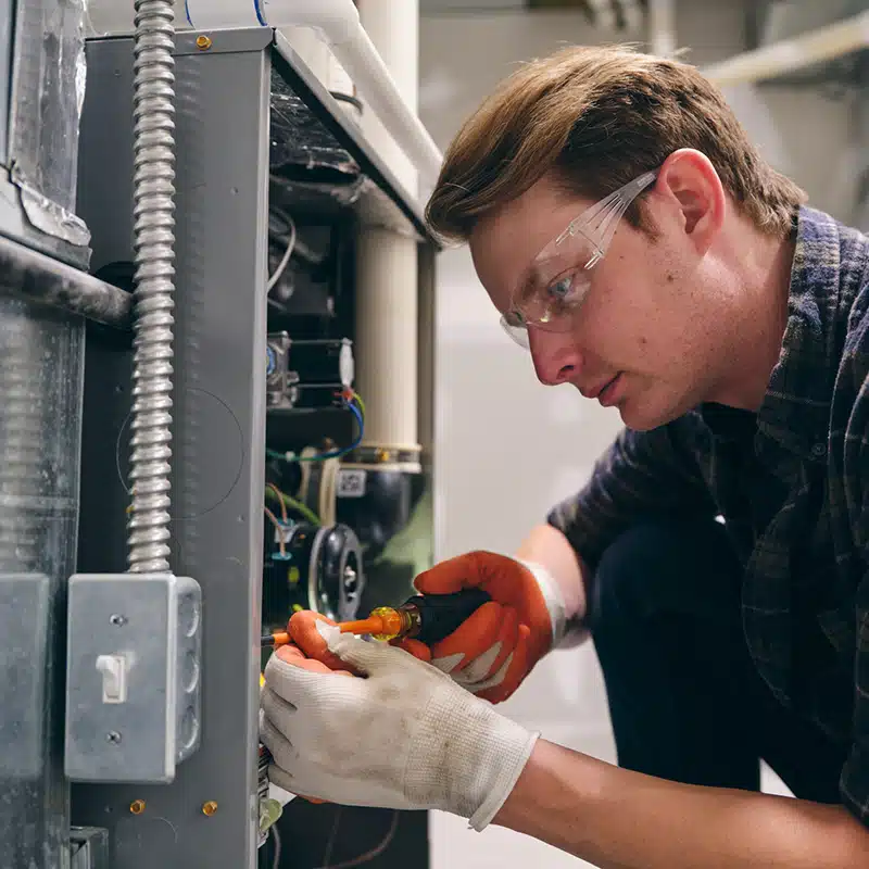 technician working on furnace - HVAC careers in Bloomington