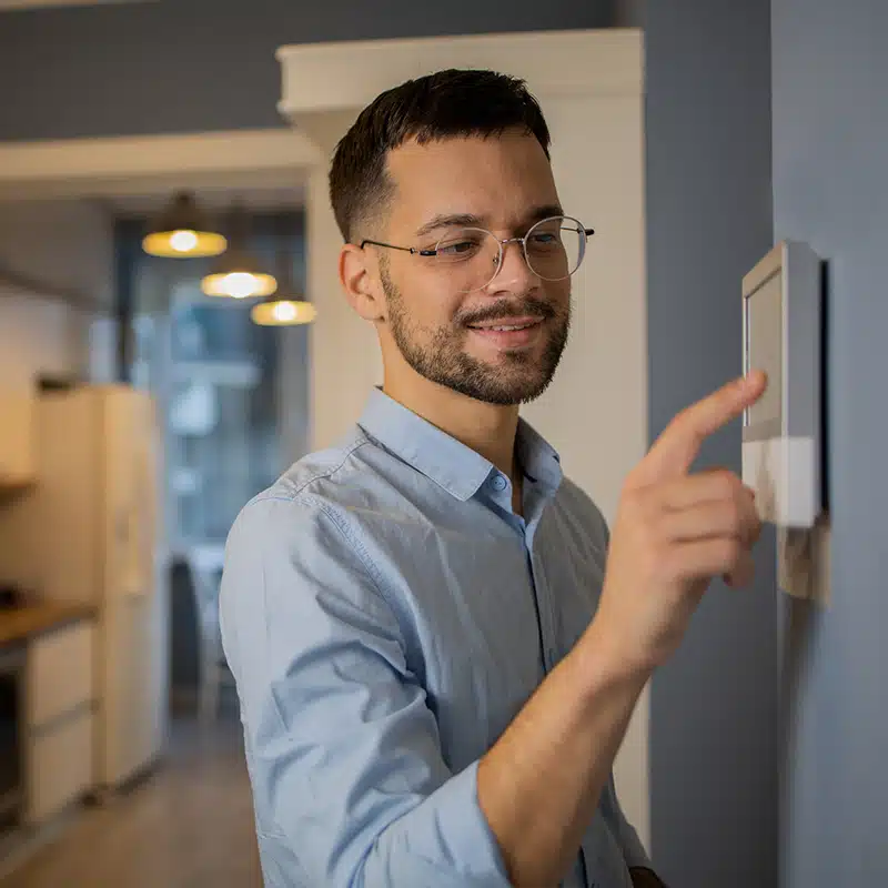 man adjusting thermostat