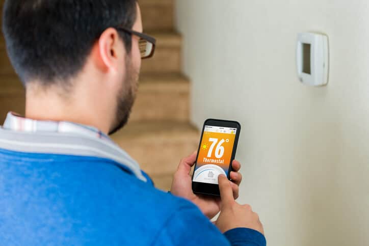 man adjusting thermostat